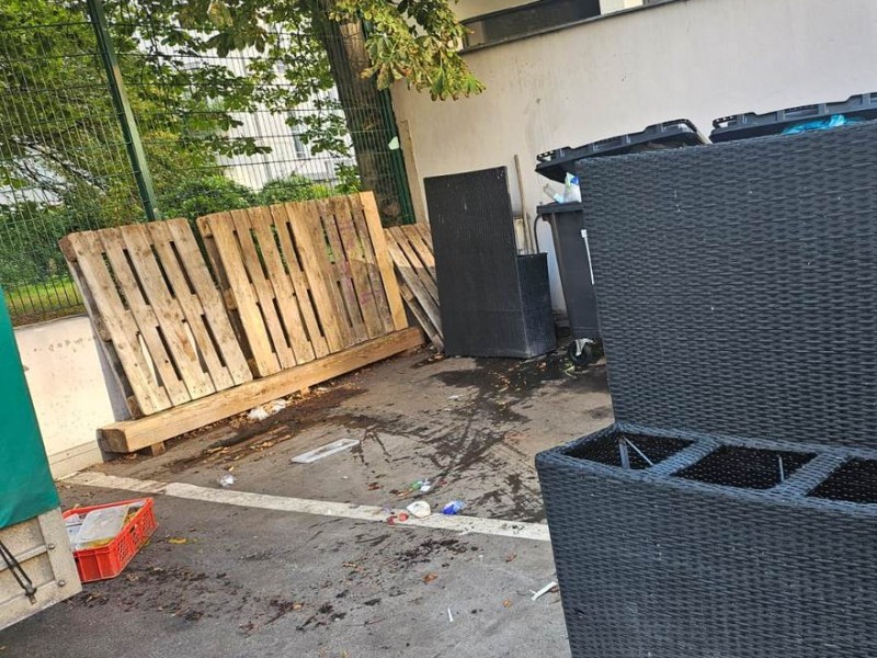 Müllstandplatz im Innenhof vor der Räumung – Paletten, ausgediente Mülltonnenboxen und Restcontainer